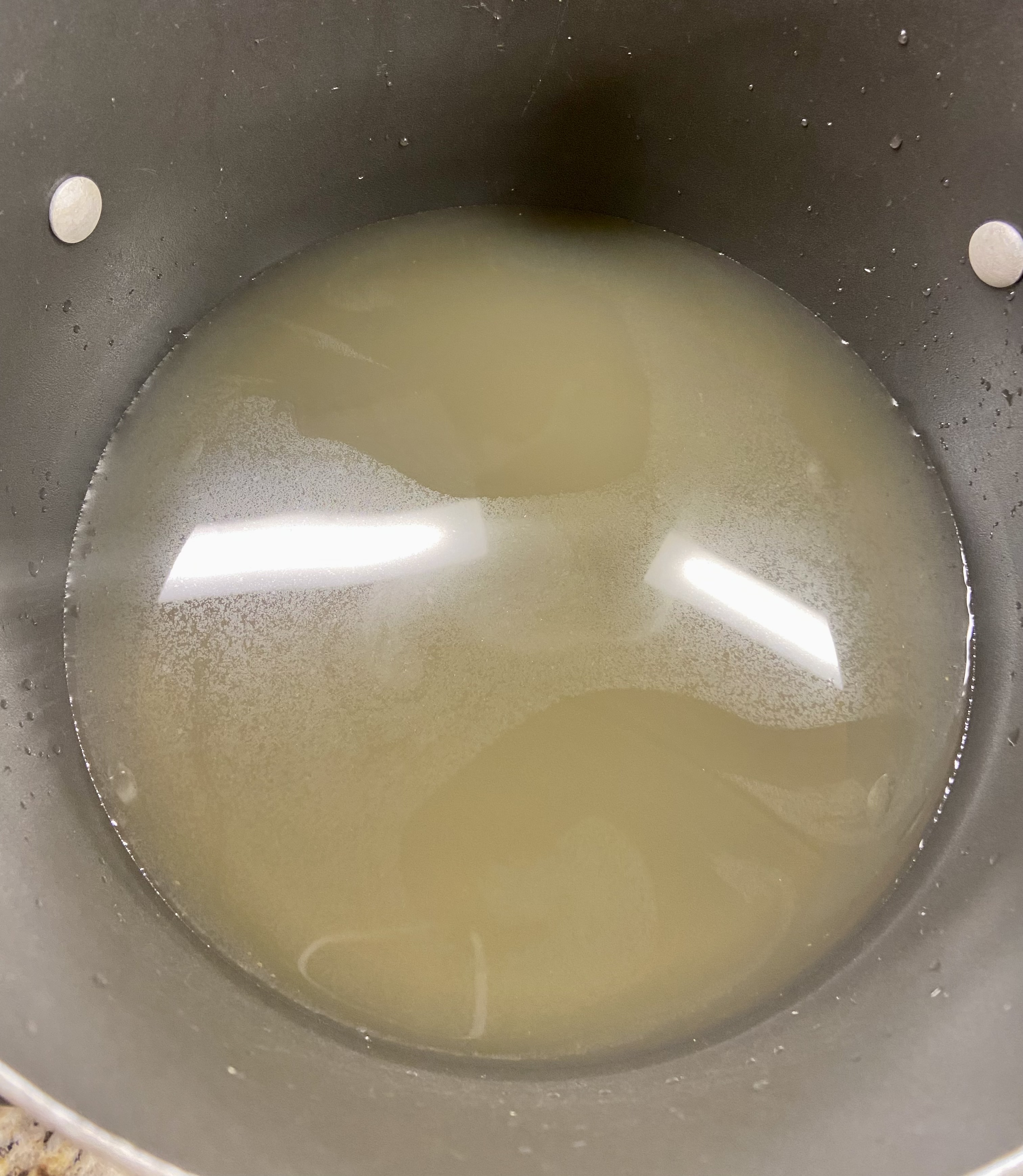 the first step to making your potato soup, chicken broth poured into a large pot