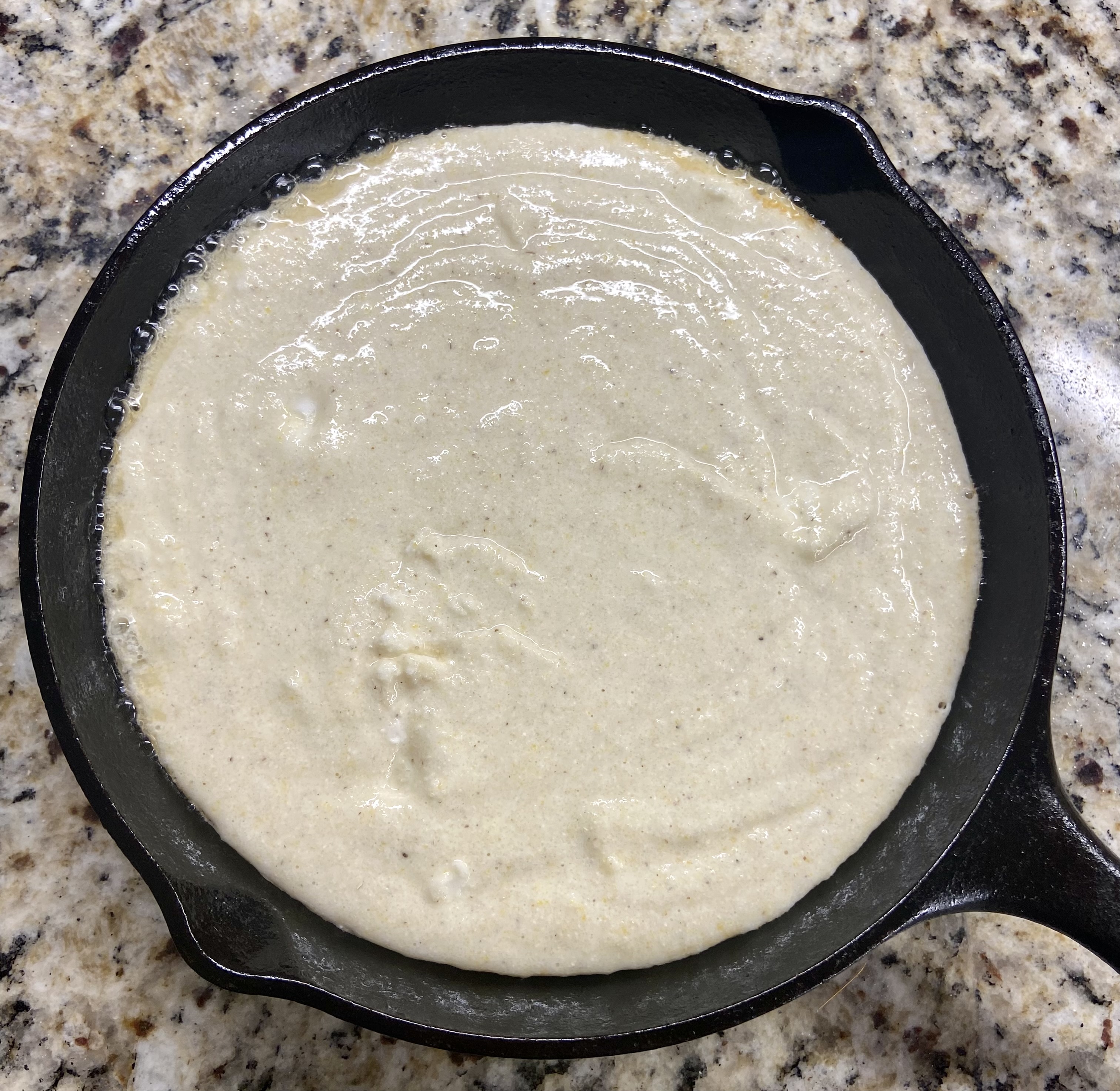 your cornbread mix poured into your hot cast iron pan